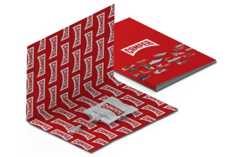 Packaging tipo carpeta decorado con el logotipo de una empresa y con una piruleta en su interior